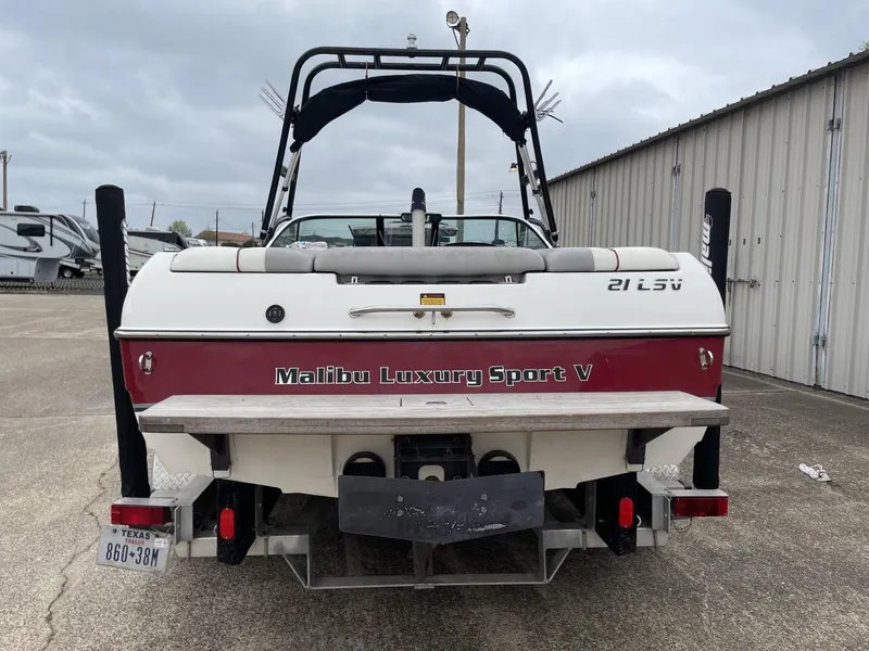 Slide: The Image of 2003 Malibu Sunscape 21 LSV boat, rear view, parked near storage units. - 10
