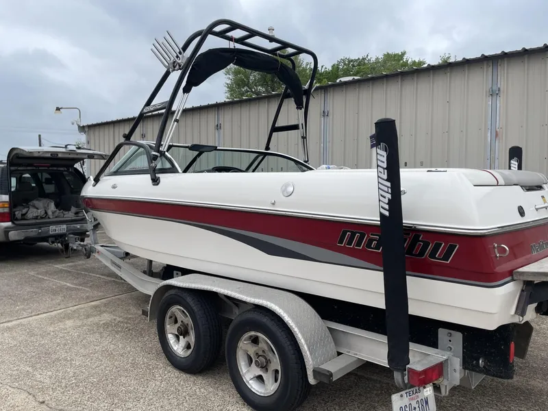 Slide: The Image of 2003 Malibu Sunscape 21 LSV boat on a trailer, parked outdoors. - 12