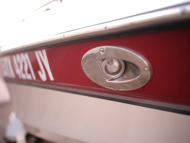 Slide: The Image of Close-up of a 2003 Malibu Sunscape 21 LSV boat with red and white hull. - 15