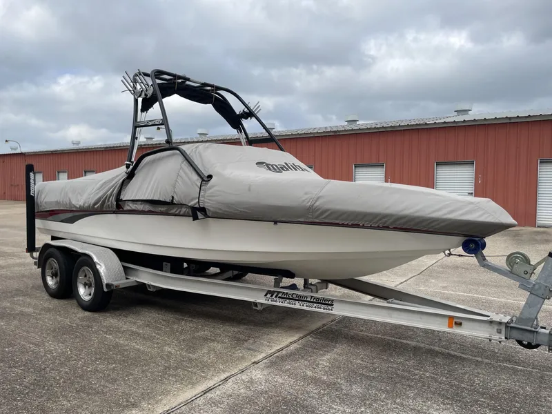 Slide: The Image of 2003 Malibu Sunscape 21 LSV boat on trailer with cover, parked outside storage units. - 8