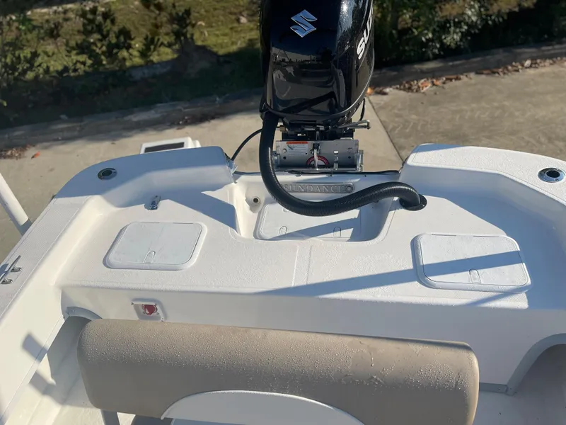 Slide: The Image of 2024 Sundance B20CCR boat with Suzuki outboard motor, rear seating, and storage compartments. - 10