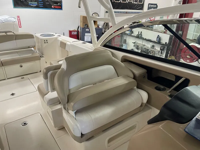Slide: The Image of 2018 Robalo R317 Dual Console boat interior with beige seating and helm station. - 10