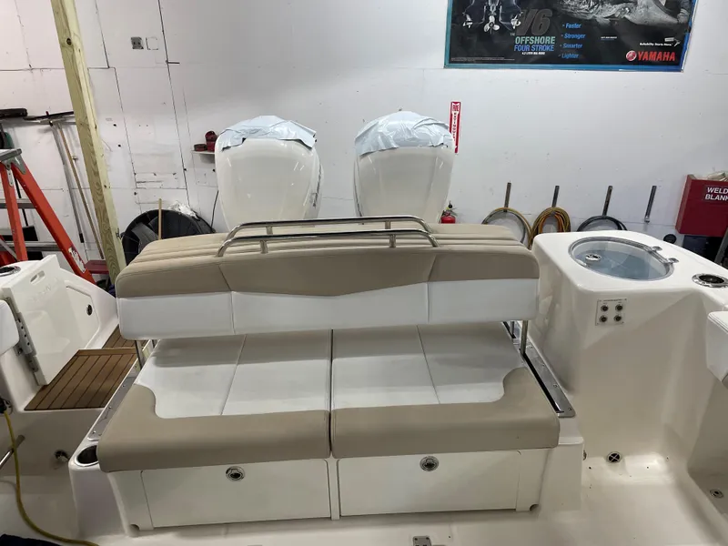 Slide: The Image of 2018 Robalo R317 Dual Console boat with twin engines and beige seating. - 12
