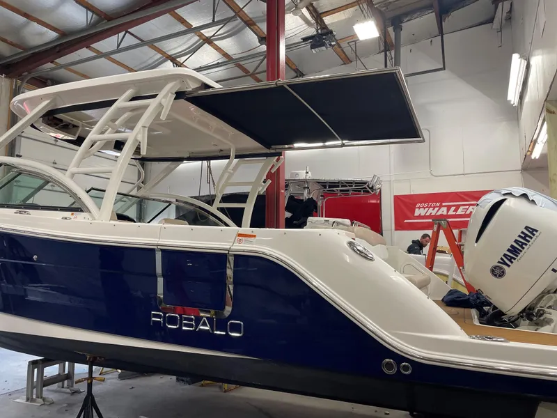 Slide: The Image of 2018 Robalo R317 Dual Console boat in a workshop with Yamaha outboard motor. - 15