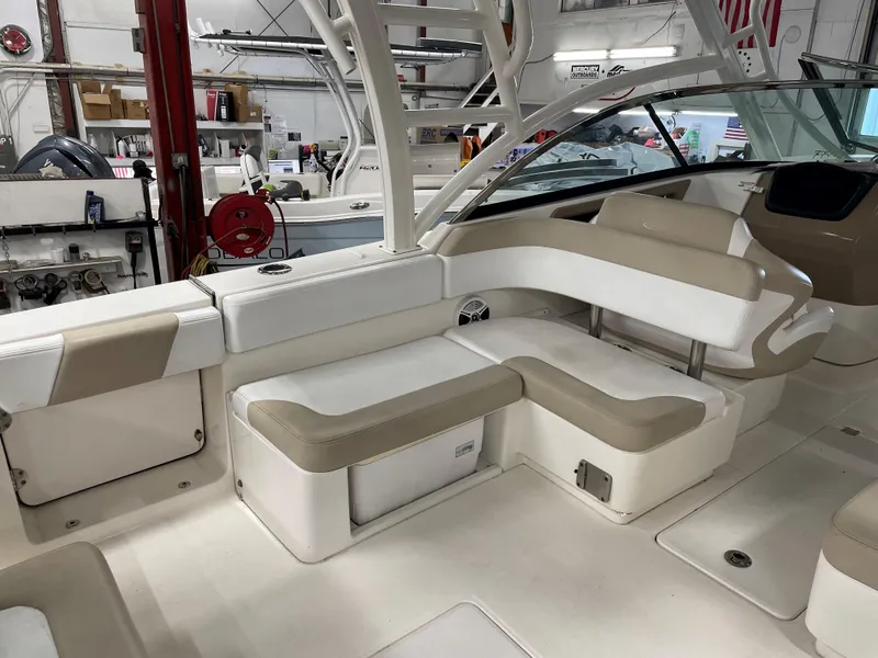 Slide: The Image of 2018 Robalo R317 Dual Console boat interior with beige and white seating. - 8