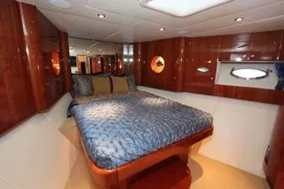 Slide: The Image of Luxurious bedroom interior of a 2001 Precision Convertible yacht with wood paneling and porthole windows. - 22