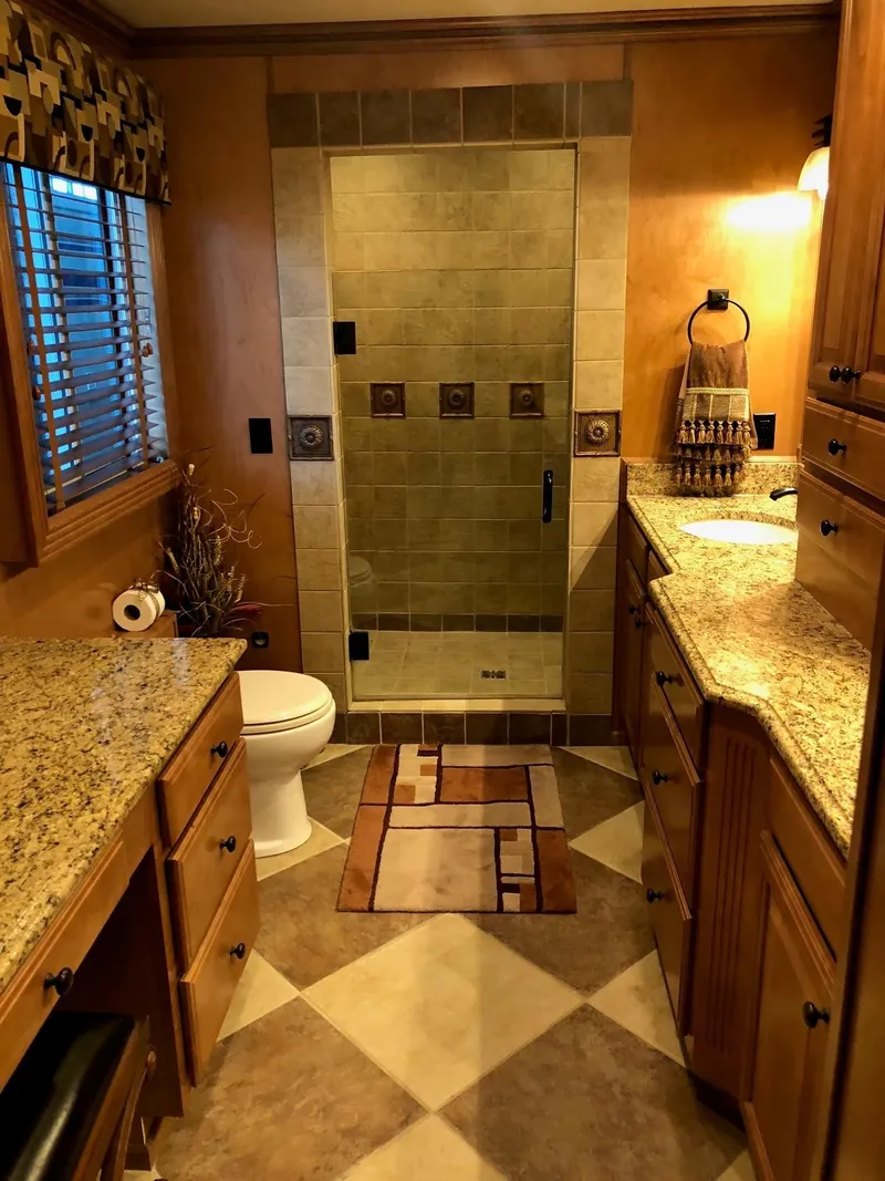 Slide: The Image of Luxurious bathroom in a 2008 Sumerset Houseboat 20' x 100' with granite countertops and tiled shower. - 16