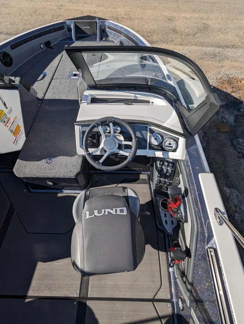 Slide: The Image of 2025 Lund 202 Pro-V GL boat interior with steering wheel and seating. - 10