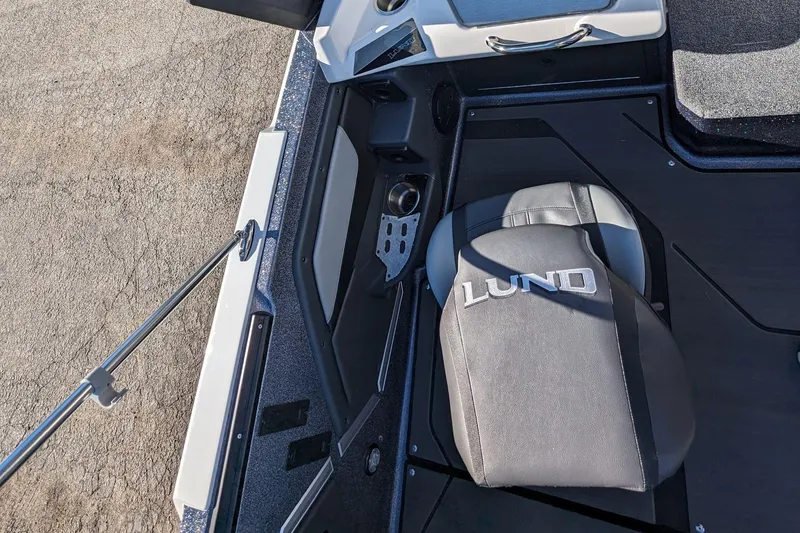 Slide: The Image of 2025 Lund 202 Pro-V GL boat interior with branded seat and storage compartments. - 14