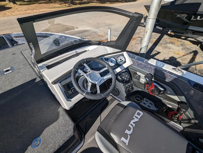 Slide: The Image of 2025 Lund 202 Pro-V GL boat interior with steering wheel and control panel. - 9