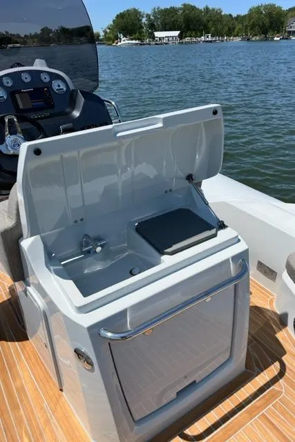 Slide: The Image of 2024 SACS Strider 900 boat interior with open kitchenette and lake view. - 7