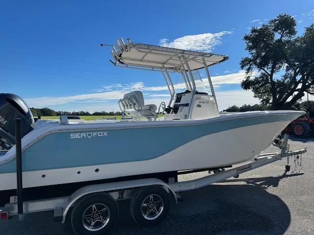 Slide: The Image of 2024 Sea Fox 248 Commander boat on a trailer under a clear blue sky. - 4