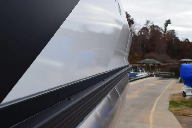 Slide: The Image of Close-up of 2024 Manitou 22' Cruise Switchback Stealth boat at a dock. - 10