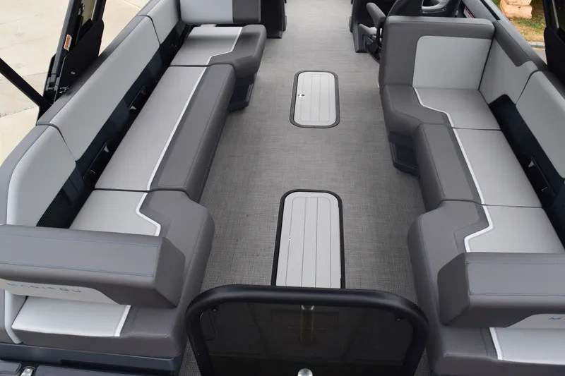 Slide: The Image of 2024 Manitou 22' Cruise Switchback Stealth interior with gray and white seating. - 20