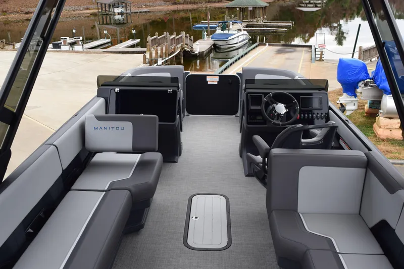 Slide: The Image of 2024 Manitou 22' Cruise Switchback Stealth pontoon boat interior at dock. - 21