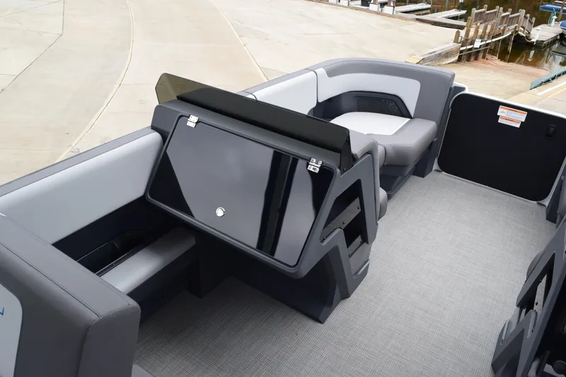 Slide: The Image of 2024 Manitou 22' Cruise Switchback Stealth boat interior with modern seating and sleek design. - 24