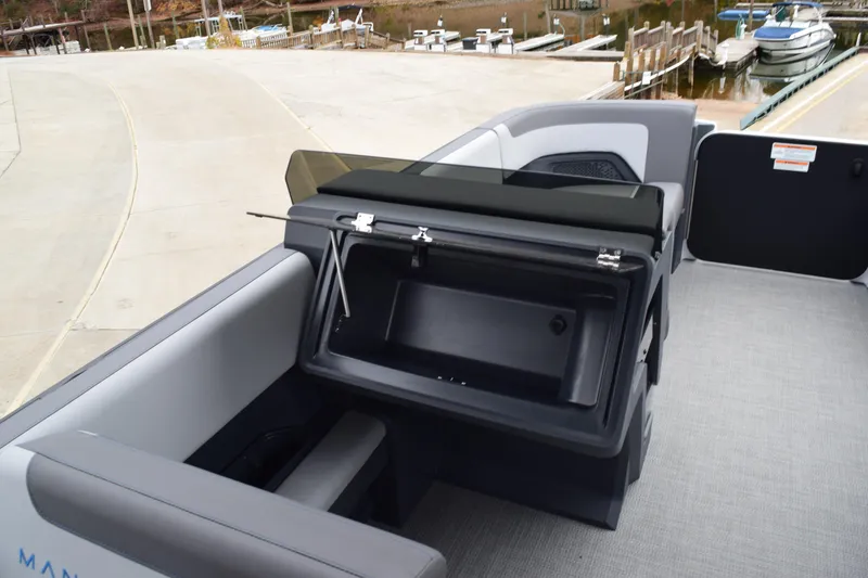 Slide: The Image of 2024 Manitou 22' Cruise Switchback Stealth boat interior with open storage compartment. - 25