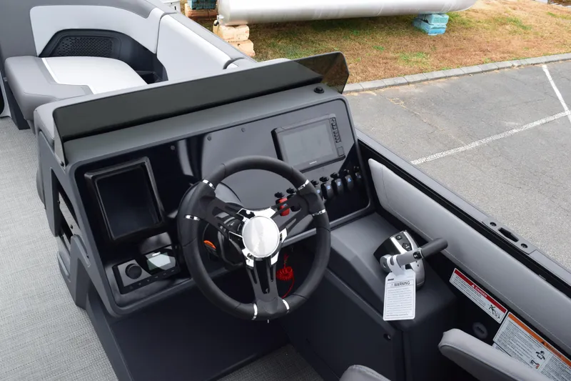 Slide: The Image of 2024 Manitou 22' Cruise Switchback Stealth boat dashboard and steering wheel. - 26