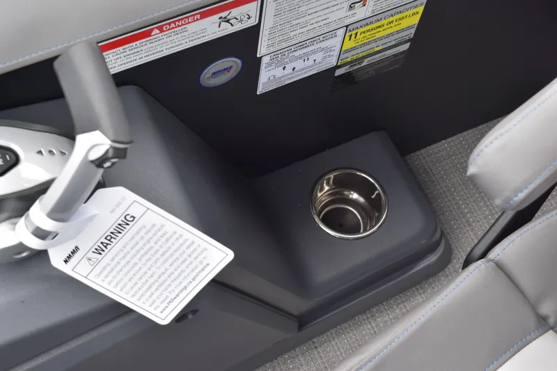 Slide: The Image of 2024 Manitou 22' Cruise Switchback Stealth boat console with cup holder and warning label. - 31