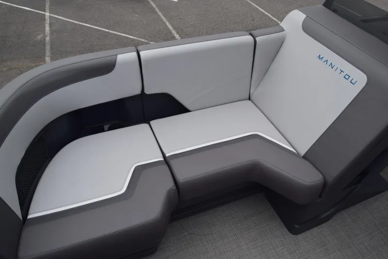 Slide: The Image of 2024 Manitou 22' Cruise Switchback Stealth boat seating with gray and white upholstery. - 39