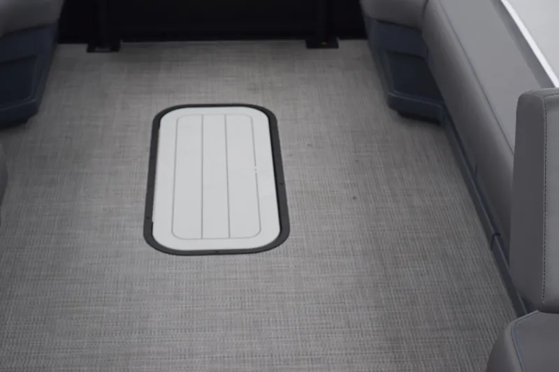 Slide: The Image of 2024 Manitou 22' Cruise Switchback Stealth boat interior with gray flooring and seating. - 41