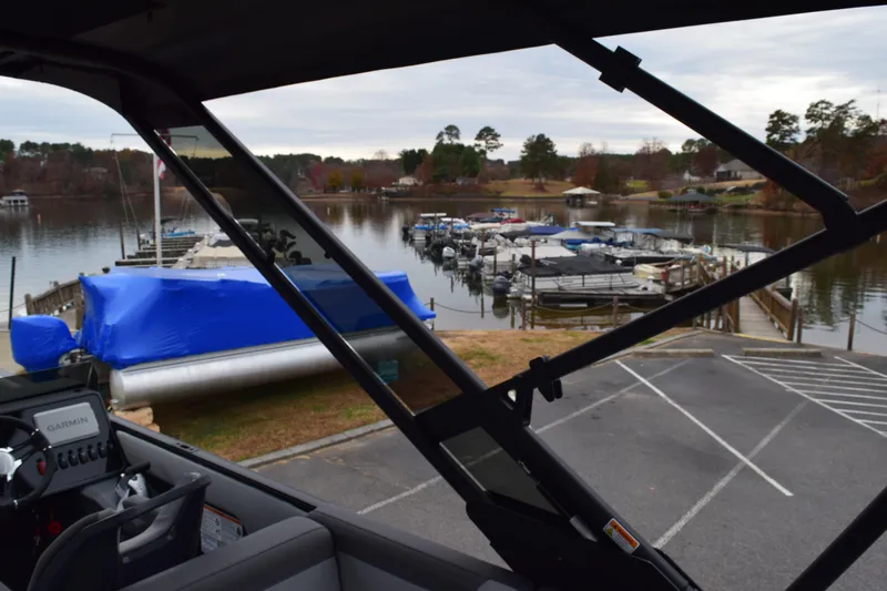 Slide: The Image of View from 2024 Manitou 22' Cruise Switchback Stealth at a lakeside marina. - 45