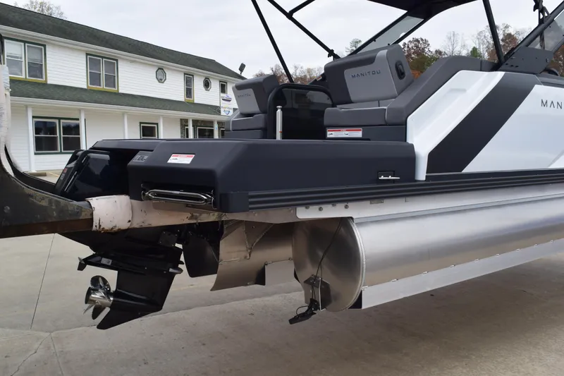 Slide: The Image of 2024 Manitou 22' Cruise Switchback Stealth pontoon boat rear view with outboard motor. - 6