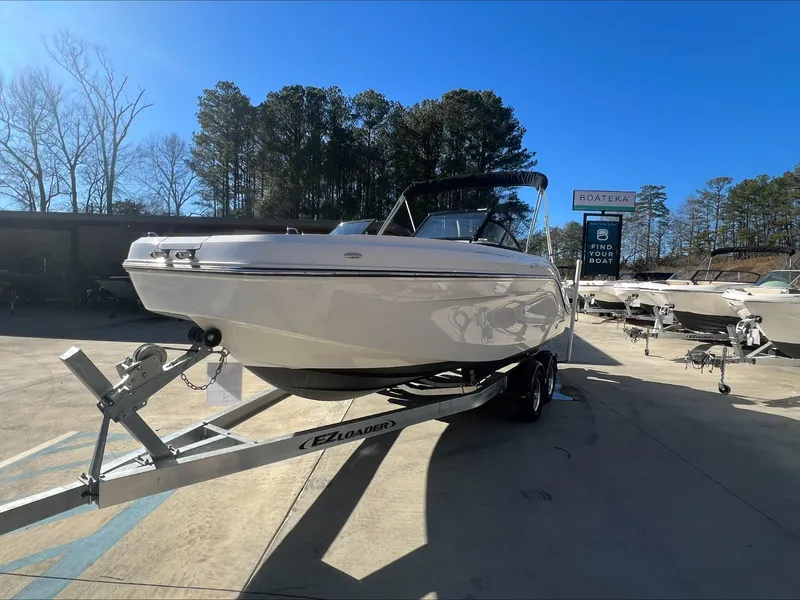 The Image of 2021 Bayliner DX 2200 boat on a trailer under a clear sky. - 0