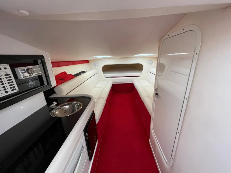 Slide: The Image of 2007 Donzi 38 ZR cabin interior with red and white upholstery, kitchenette, and seating area. - 13