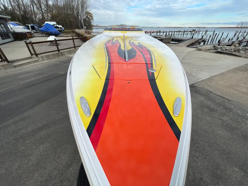 Slide: The Image of 2007 Donzi 38 ZR powerboat with vibrant red, yellow, and black paint job at a marina. - 3
