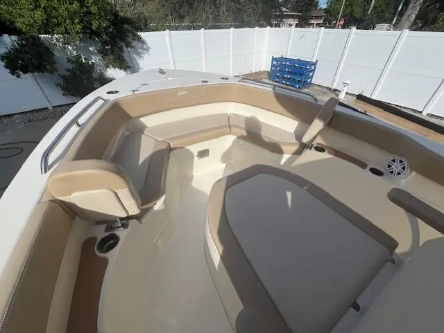 Slide: The Image of 2023 Scout 215XSF boat interior with beige seating and white deck. - 11