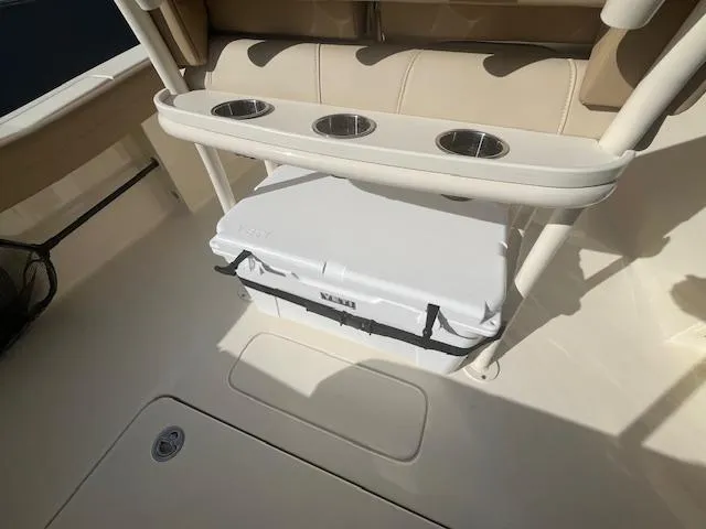 Slide: The Image of 2023 Scout 215XSF boat interior with cooler and cup holders. - 15