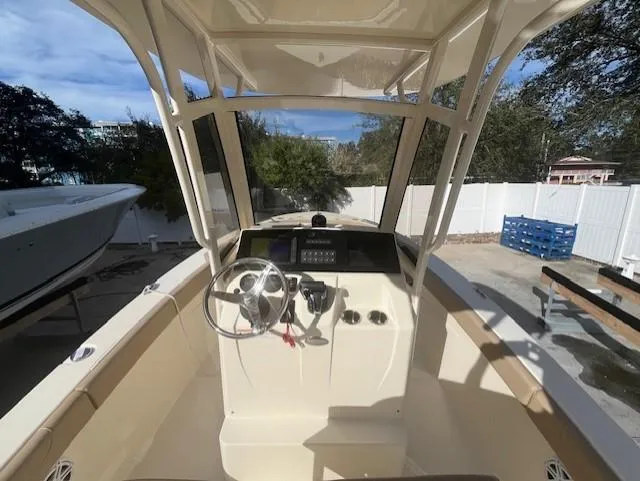 Slide: The Image of 2023 Scout 215XSF boat helm with steering wheel and control panel. - 16