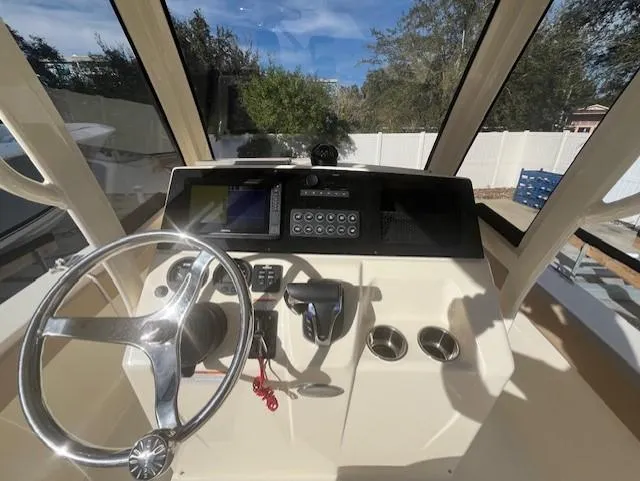 Slide: The Image of 2023 Scout 215XSF boat helm with steering wheel, control panel, and navigation system. - 17