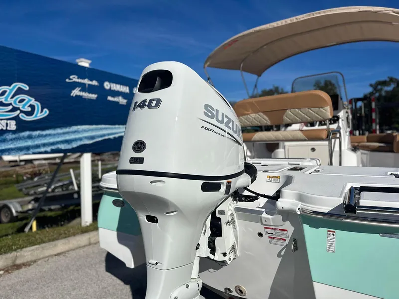 Slide: The Image of 2023 NauticStar 191 Hybrid with Suzuki 140 outboard motor, docked at a marina. - 14