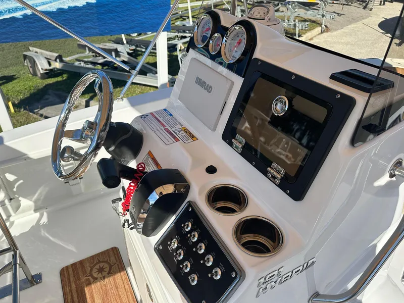 Slide: The Image of 2023 NauticStar 191 Hybrid boat console with steering wheel, gauges, and controls. - 4