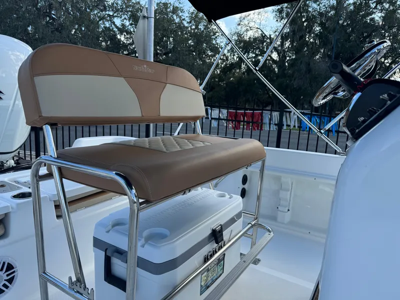Slide: The Image of 2024 NauticStar 211 Hybrid boat interior with tan seating and cooler. - 5