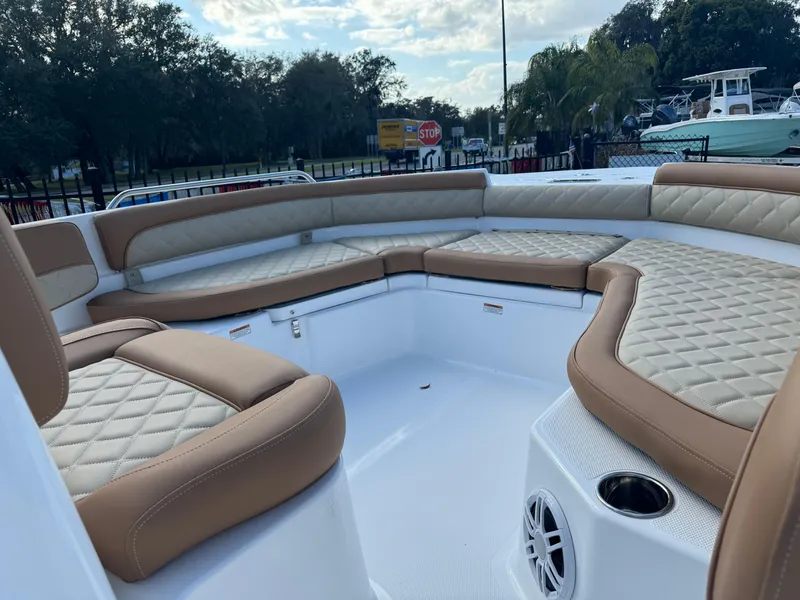 Slide: The Image of 2024 NauticStar 211 Hybrid boat with tan and white cushioned seating. - 6