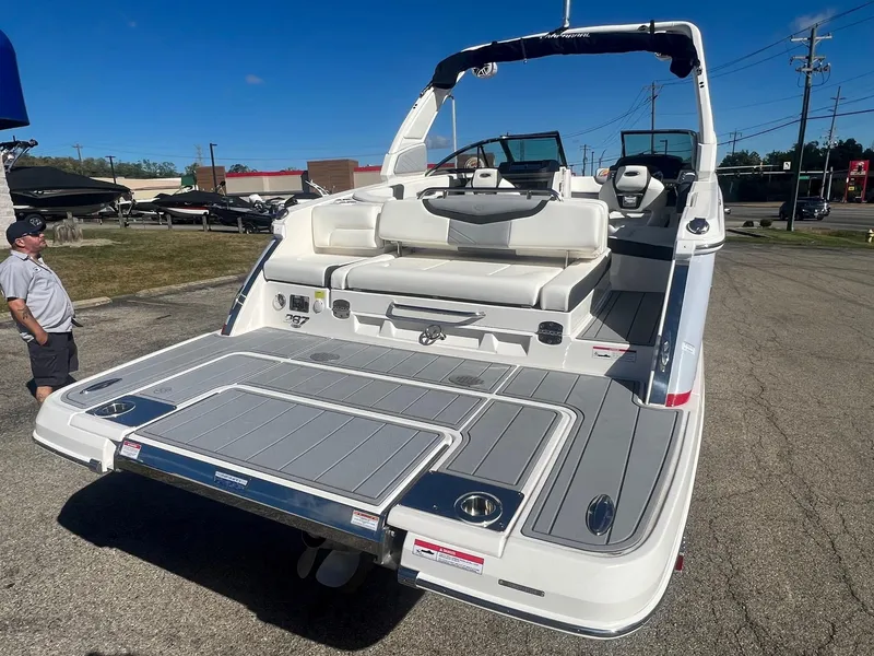 Slide: The Image of 2024 Chaparral 287 SSX boat with spacious deck and seating, parked outdoors. - 1