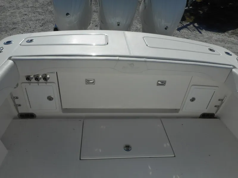 Slide: The Image of 2023 Regulator 34 boat stern with storage compartments and triple outboard engines. - 16