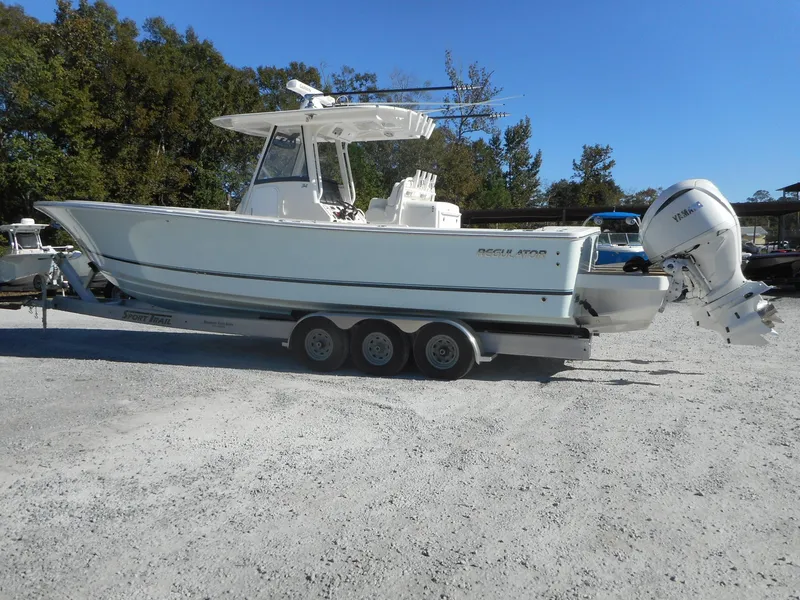 Slide: The Image of 2023 Regulator 34 boat on a trailer in a gravel lot. - 3
