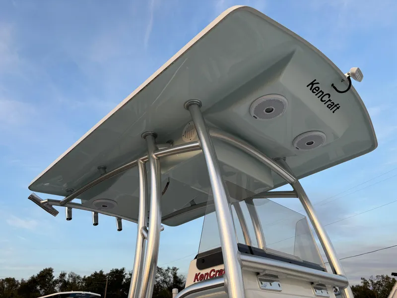 Slide: The Image of KenCraft 21 boat T-top with speakers and rod holders, 2021 model, under clear sky. - 11