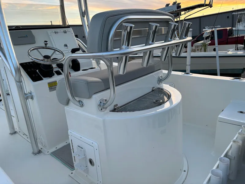 Slide: The Image of 2021 KenCraft 21 boat interior with helm, seating, and rod holders at sunset. - 17