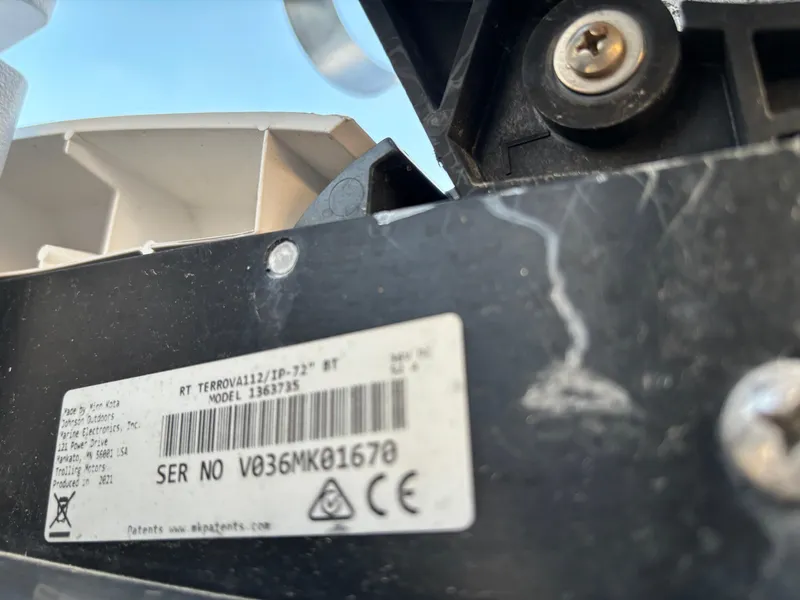 Slide: The Image of Close-up of a KenCraft 21 boat component with a visible serial number label. - 21