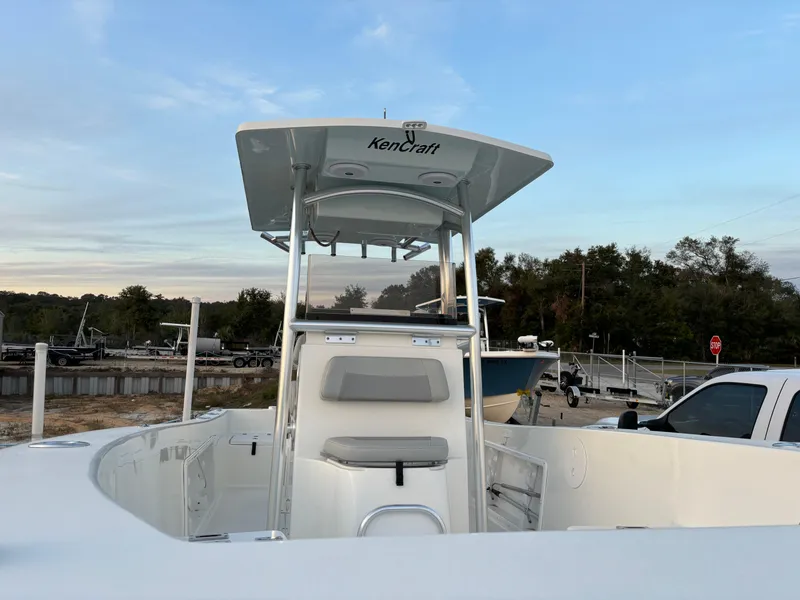 Slide: The Image of 2021 KenCraft 21 boat with center console, parked outdoors under a clear sky. - 26