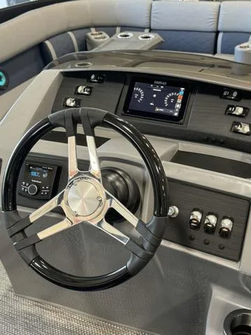 Slide: The Image of 2024 Bennington 25 LTSB boat dashboard with steering wheel and control panel. - 15