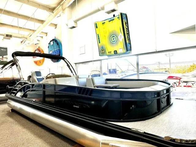 Slide: The Image of 2024 Bennington 25 LTSB pontoon boat in a warehouse, covered with a black tarp. - 8