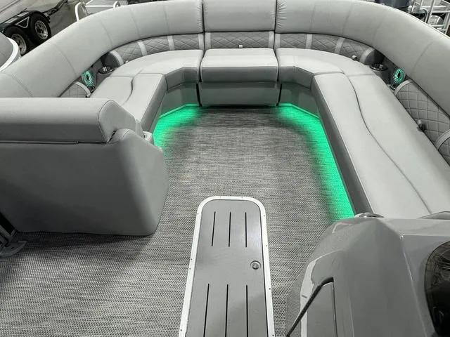 Slide: The Image of 2024 Bennington 23 LSB pontoon boat interior with gray seating and green LED lighting. - 15