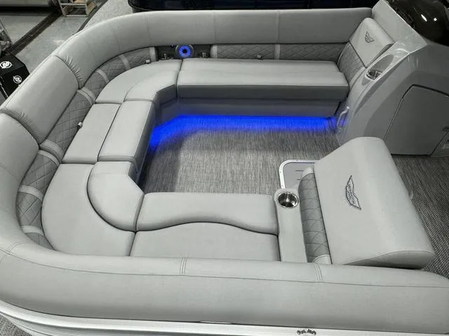 Slide: The Image of 2024 Bennington 23 LSB boat interior with gray seating and blue LED lighting. - 21