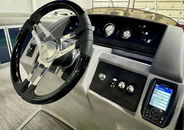 Slide: The Image of 2024 Bennington 23 LSB boat dashboard with steering wheel and Garmin navigation system. - 23